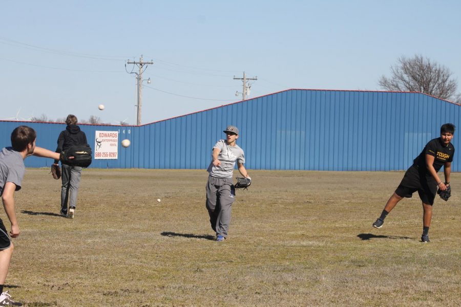 Cody Edwards (center), Evan Hines, and Alex Alvarez warm up during baseball practice. 